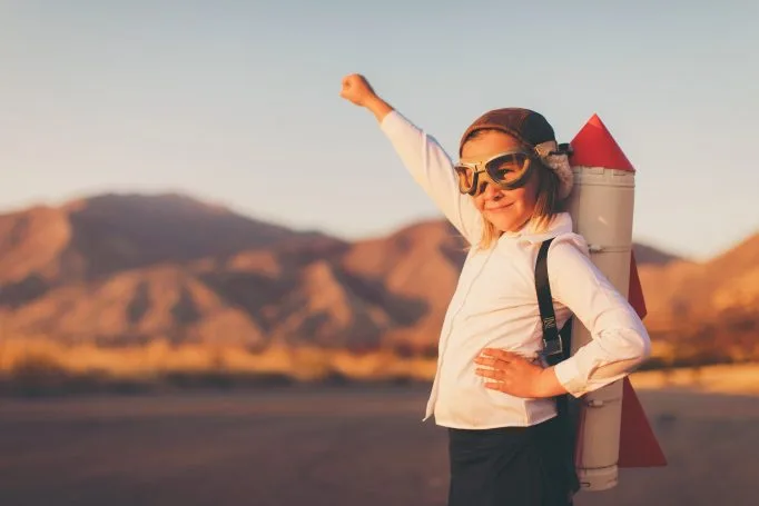 Image d'une fille levant le poing en l'air représentant la détermination, l'accomplissement d'une chose.